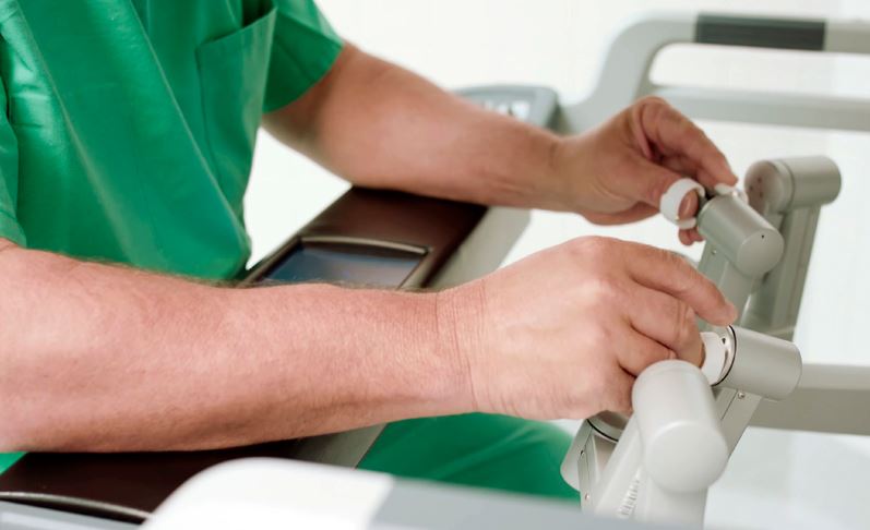 doctor doing robotic surgery with machine on his fingertips